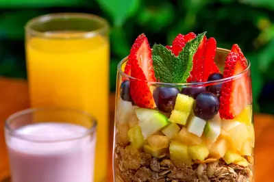 a vase filled with fruit and a glass of milk at Hotel Playa Club in Cartagena de Indias