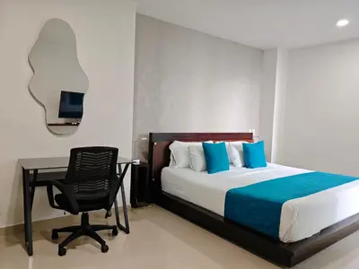 a bedroom with a bed and a desk and a chair at Edificio Morros Vitri in Cartagena de Indias