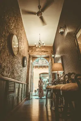 a woman standing in a hallway with a clock on the wall at The Clock Hostel & Suites in Cartagena de Indias