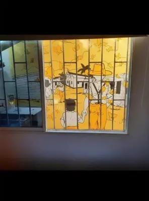 a window with a painting of a city at Casa Turística Realismo Mágico in Aracataca