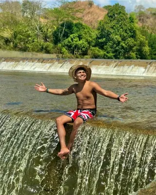 a young man sitting on top of a waterfall at Casa Turística Realismo Mágico in Aracataca