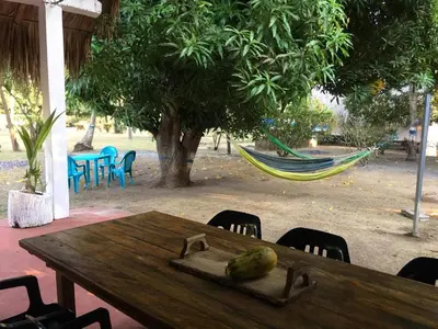 a wooden table with a hammock and a papaya on it at Luna azul in San Bernardo del Viento