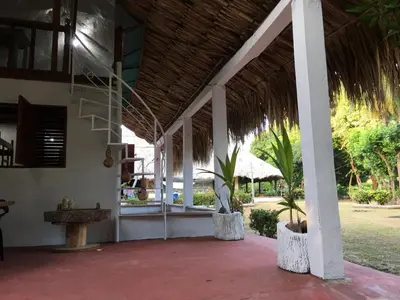 a porch of a resort with a staircase and palm trees at Luna azul in San Bernardo del Viento