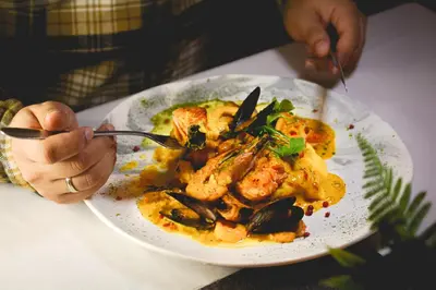 a person sitting at a table eating a plate of food at Hotel Baluarte Cartagena Boutique in Cartagena de Indias