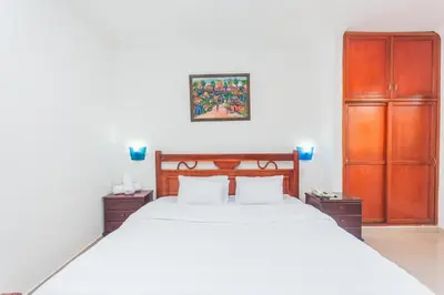 a bedroom with a large white bed and wooden cabinets at Hotel Baluarte Cartagena Boutique in Cartagena de Indias