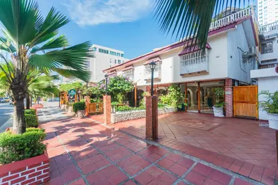 a street with palm trees and a building at Hotel Baluarte Cartagena Boutique in Cartagena de Indias