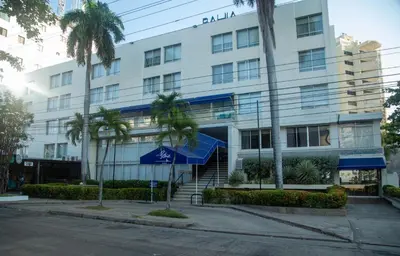 a building with palm trees in front of it at Hotel Bahia Cartagena in Cartagena de Indias