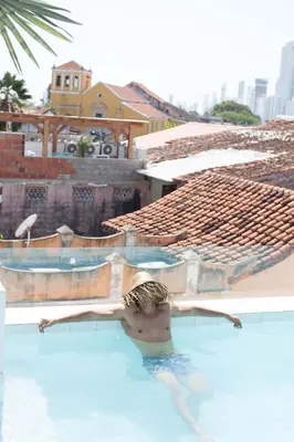 a man in a swimming pool with his arms outstretched at Hotel Casa Lola Deluxe Gallery in Cartagena de Indias