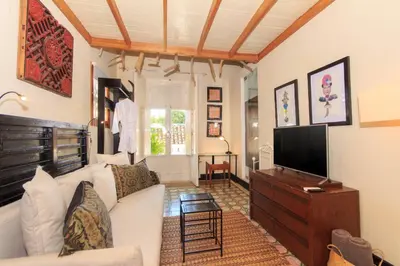 a living room with a white couch and a tv at Hotel Casa Lola Deluxe Gallery in Cartagena de Indias