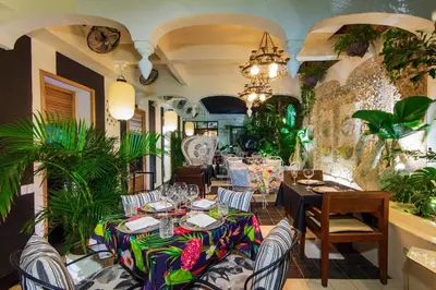 a dining room with a table and chairs and plants at Hotel Casa Lola Deluxe Gallery in Cartagena de Indias
