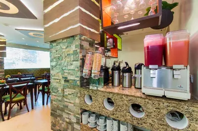 a restaurant with a counter with a drink dispenser at Hotel Aixo Suites By GEH Suites in Cartagena de Indias