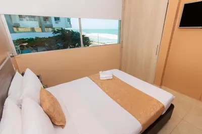 a bedroom with a bed with a view of the ocean at Hotel Aixo Suites By GEH Suites in Cartagena de Indias