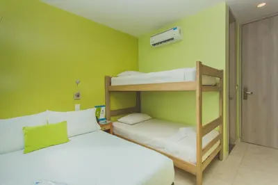 a small room with two bunk beds and a door at Hotel Aixo Suites By GEH Suites in Cartagena de Indias