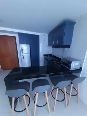 a kitchen with a black counter and four stools at El Nuevo Conquistador in Cartagena de Indias