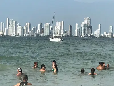 a group of people swimming in the water with a city at El Nuevo Conquistador in Cartagena de Indias