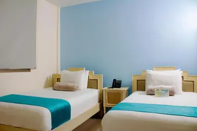 two beds sitting next to each other in a room at Hotel Med Barranquilla Centro in Barranquilla