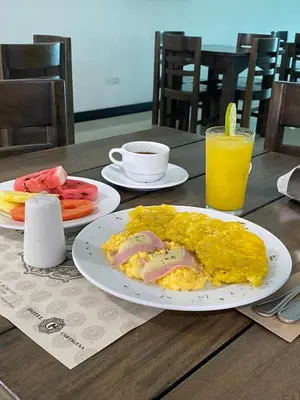 a breakfast of eggs and fruit and a glass of orange juice at Hotel G Cartagena in Cartagena de Indias