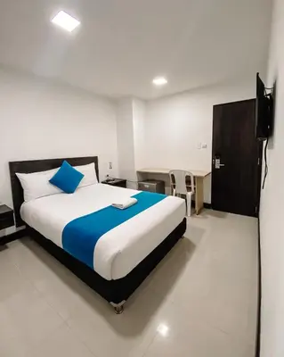 a bedroom with a large bed and a desk at Hotel G Cartagena in Cartagena de Indias