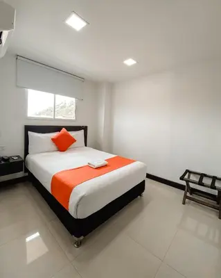 a bedroom with a bed with an orange pillow at Hotel G Cartagena in Cartagena de Indias