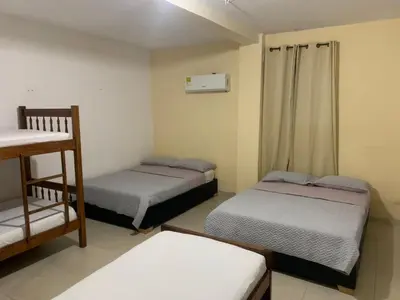 a small room with two beds and a shelf at Hotel Rosandy Galaxy in Cartagena de Indias