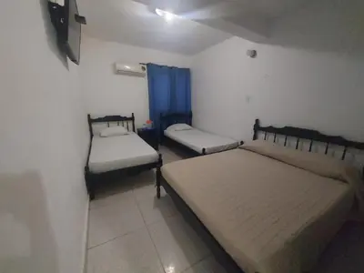 a bedroom with two beds and a blue curtain at Hotel Rosandy Galaxy in Cartagena de Indias