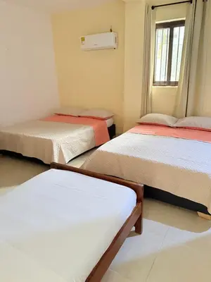 a room with three beds and a window at Hotel Rosandy Galaxy in Cartagena de Indias