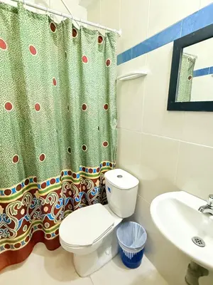 a bathroom with a toilet and a shower curtain at Hotel Rosandy Galaxy in Cartagena de Indias