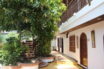 a courtyard of a house with trees and a door at Hotel Casa Colonial in Barranquilla