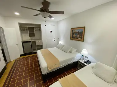 a bedroom with a bed and a ceiling fan at Hotel Casa Colonial in Barranquilla