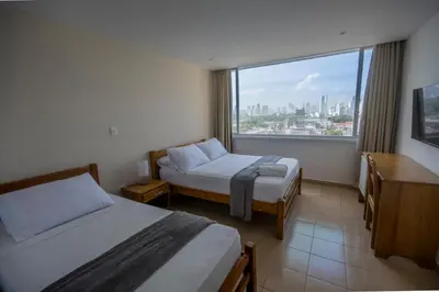 a hotel room with two beds and a large window at Hotel Stil Cartagena in Cartagena de Indias