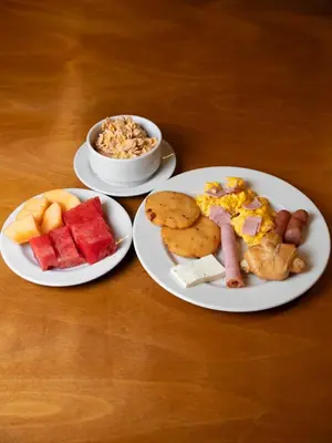 three plates of food on a wooden table at Hotel Stil Cartagena in Cartagena de Indias