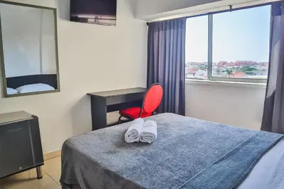 a bedroom with a bed and a red chair at Hotel Stil Cartagena in Cartagena de Indias