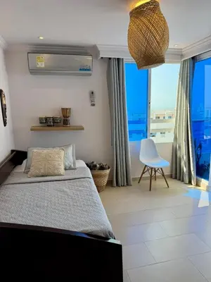 a bedroom with a bed and a chair and a window at Apartamentos Cartagena Colonial in Cartagena de Indias