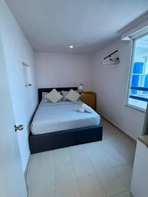 a bedroom with a bed in a white room at Apartamentos Cartagena Colonial in Cartagena de Indias