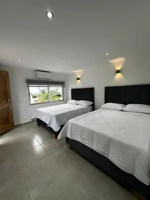 a bedroom with two beds and a window at Hotel Boutique Casa Berastegui in Puerto Colombia