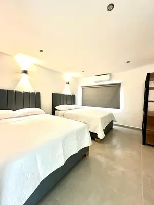 a bedroom with two beds and a large window at Hotel Boutique Casa Berastegui in Puerto Colombia