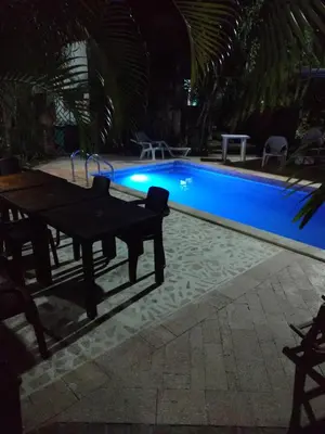 a swimming pool at night with a table next to it at Hotel Boutique Casa Berastegui in Puerto Colombia