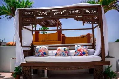 a wooden bench with pillows on a balcony at Hotel Aguamarina Boutique in Cartagena de Indias