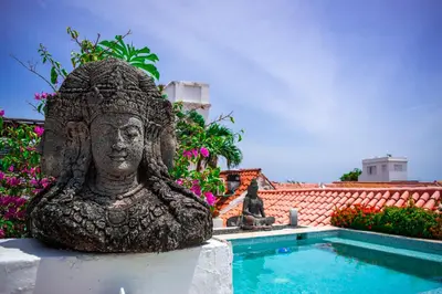 a statue sitting next to a swimming pool at Hotel Aguamarina Boutique in Cartagena de Indias
