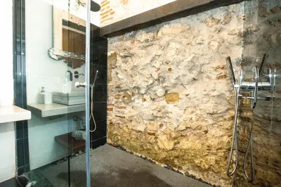 a stone wall in a bathroom with a shower at Hotel Aguamarina Boutique in Cartagena de Indias