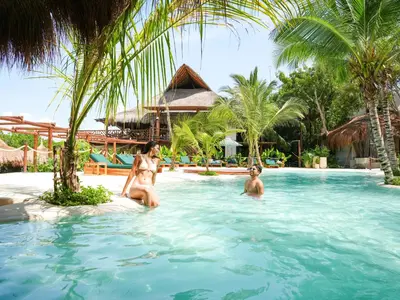 two women in the swimming pool at a resort at Aura Hotel Barú in Baru