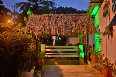 a building with a thatch roof and a pathway at Cabañas Los Juanchos Coveñas in Coveñas