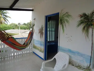a room with a hammock and a balcony with a door at Cabañas Los Juanchos Coveñas in Coveñas