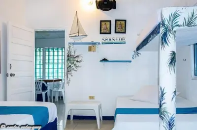 a bedroom with two beds and a table and a window at Cabañas Los Juanchos Coveñas in Coveñas