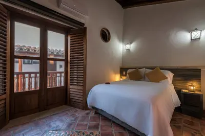 a bedroom with a large white bed and a window at Getsemani Cartagena Hotel in Cartagena de Indias