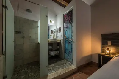 a bathroom with a shower and a sink and a door at Getsemani Cartagena Hotel in Cartagena de Indias