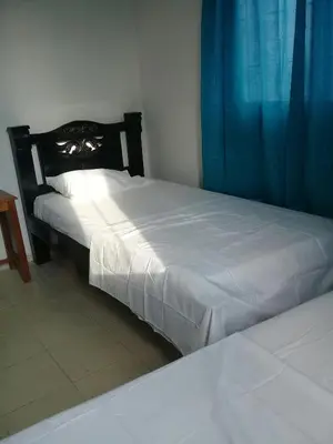 a bedroom with two beds and a blue curtain at Hotel Paseo Bolivar in Cartagena de Indias