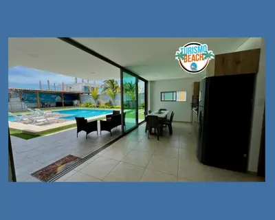 a living room with a dining room table and a pool at Palmares Beach in Tubará