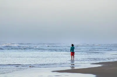 a man standing on the beach looking at the ocean at Palmares Beach in Tubará