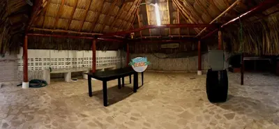 a room with a table in a straw hut at Blue Gold Beach in Juan de Acosta